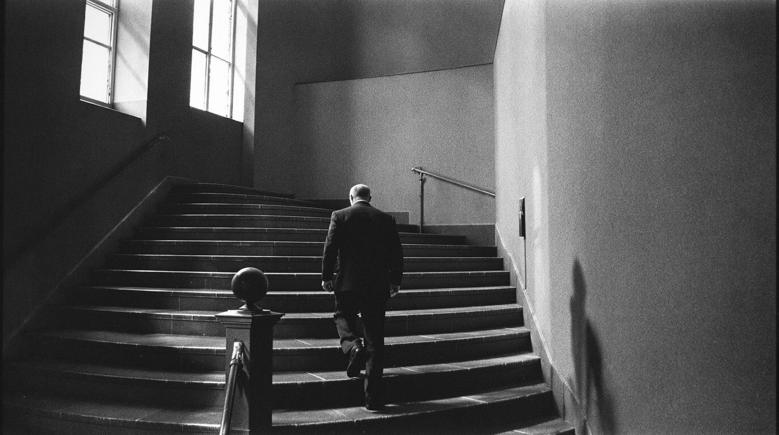 Mann steigt eine Treppe in einem Verwaltungsgebäude hinauf